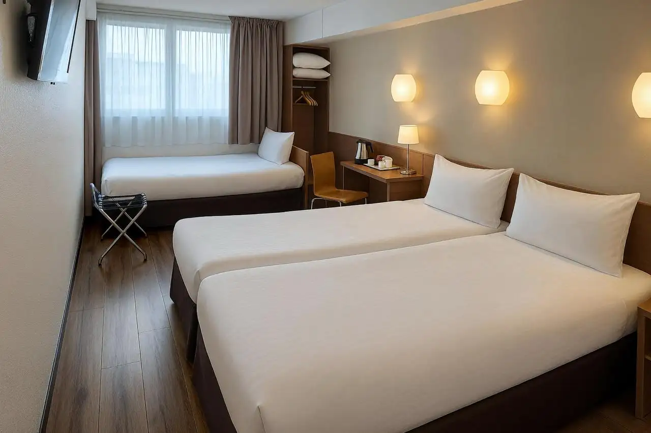 Chambre d'hu00f4tel avec trois lits simples.